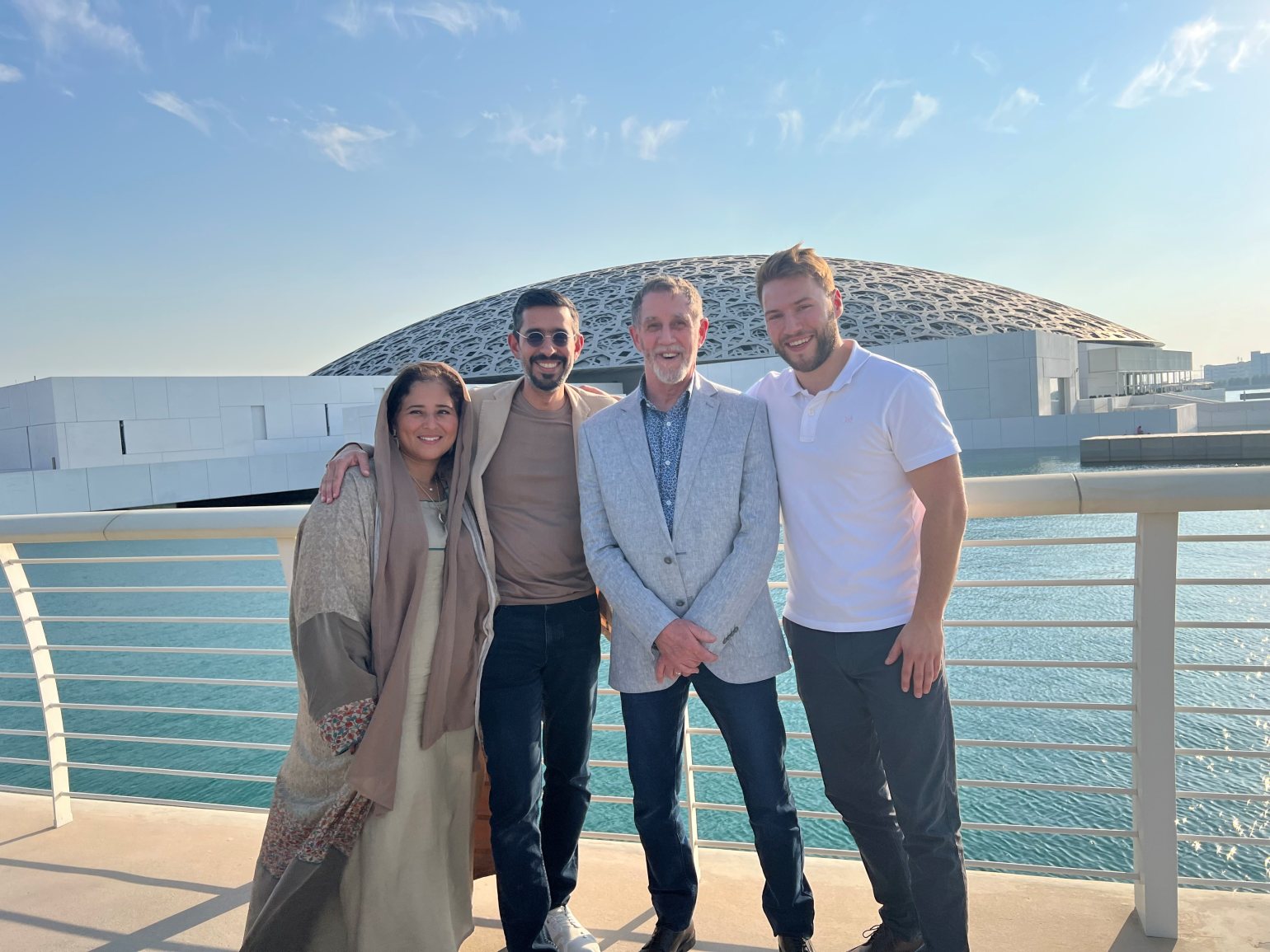 Plan extérieur du Louvre Abu Dhabi, mettant en valeur le toit en dôme argenté et l'architecture en blocs de béton.